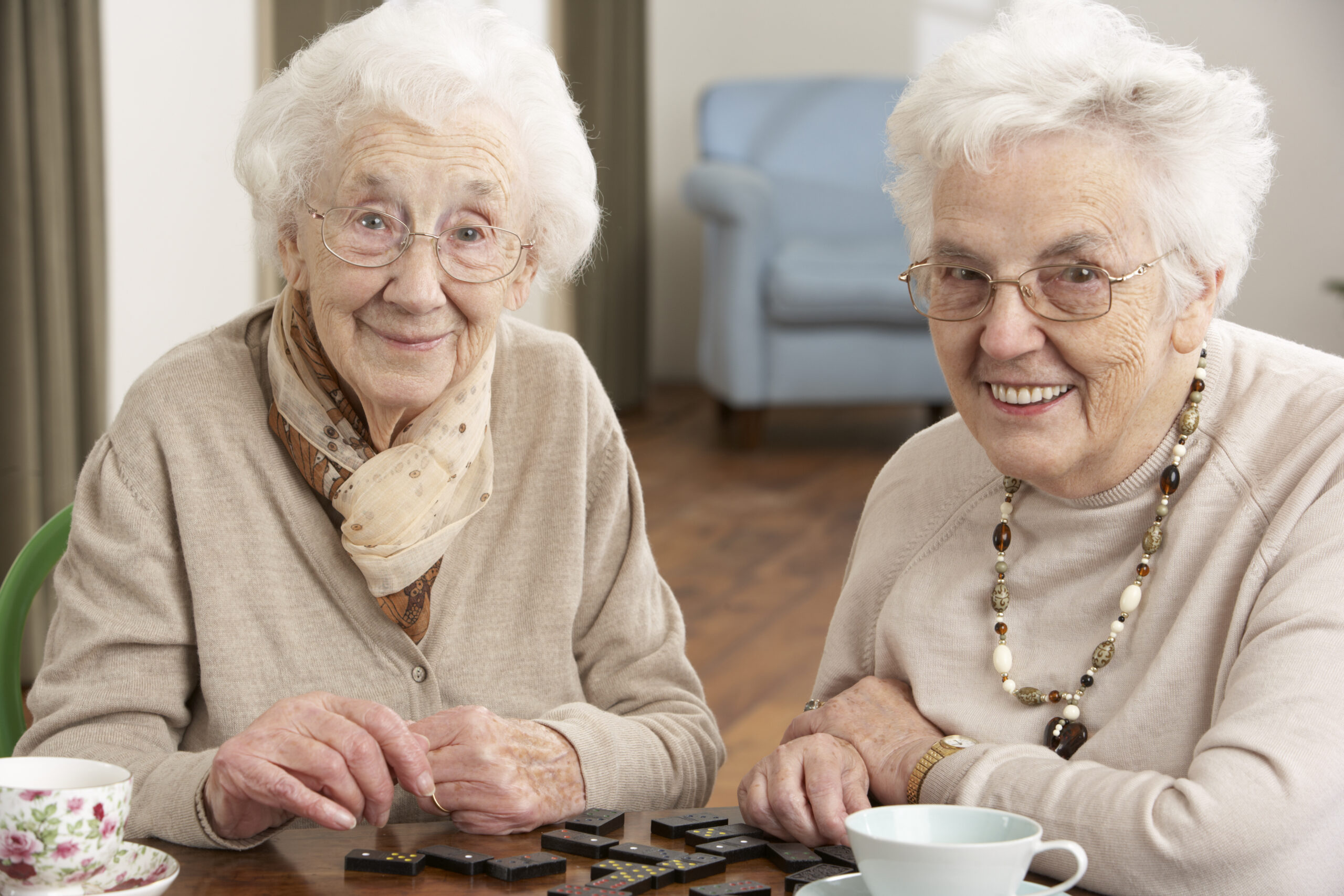 Two Senior Women Playing Dominoes At Senior Center